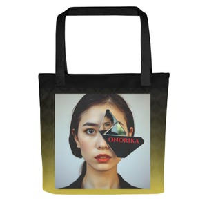 Peut inclure: Sac fourre-tout noir avec un dégradé jaune et noir. Le sac présente un portrait d'une personne avec un miroir géométrique sur le visage. Le mot "ONORIKA" est imprimé en rouge sur le miroir.