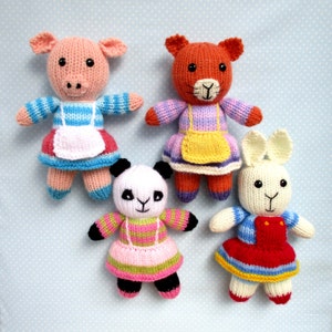 May include: Four knitted stuffed animals wearing dresses. A pink pig, a brown bear, a white panda, and a white rabbit. The animals are all wearing colorful dresses with aprons.