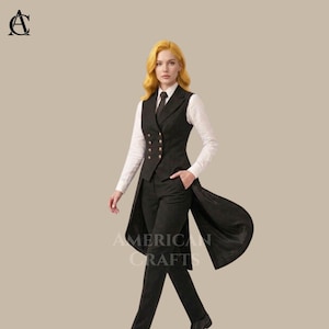 May include: A black suit with a long vest, white shirt, and tie. The vest has gold buttons and a long, flowing back. The text "AMERICAN CRAFTS" is visible on the suit. The suit is tailored and worn by a person.