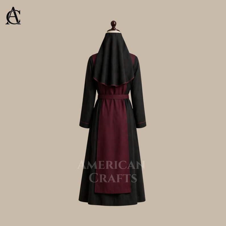 May include: A black and burgundy robe with a matching head covering. The long-sleeved garment features a burgundy panel down the front and a burgundy belt. The text "AMERICAN CRAFTS" is printed on the lower portion of the robe.
