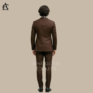 Puede incluir: Un traje marr&oacute;n, que consta de una chaqueta de dos botones y un pantal&oacute;n a juego. El traje es de color liso y parece estar hecho de una tela suave. Las palabras "AMERICAN CRAFTS" est&aacute;n impresas en el pantal&oacute;n. El traje lo lleva una persona.
