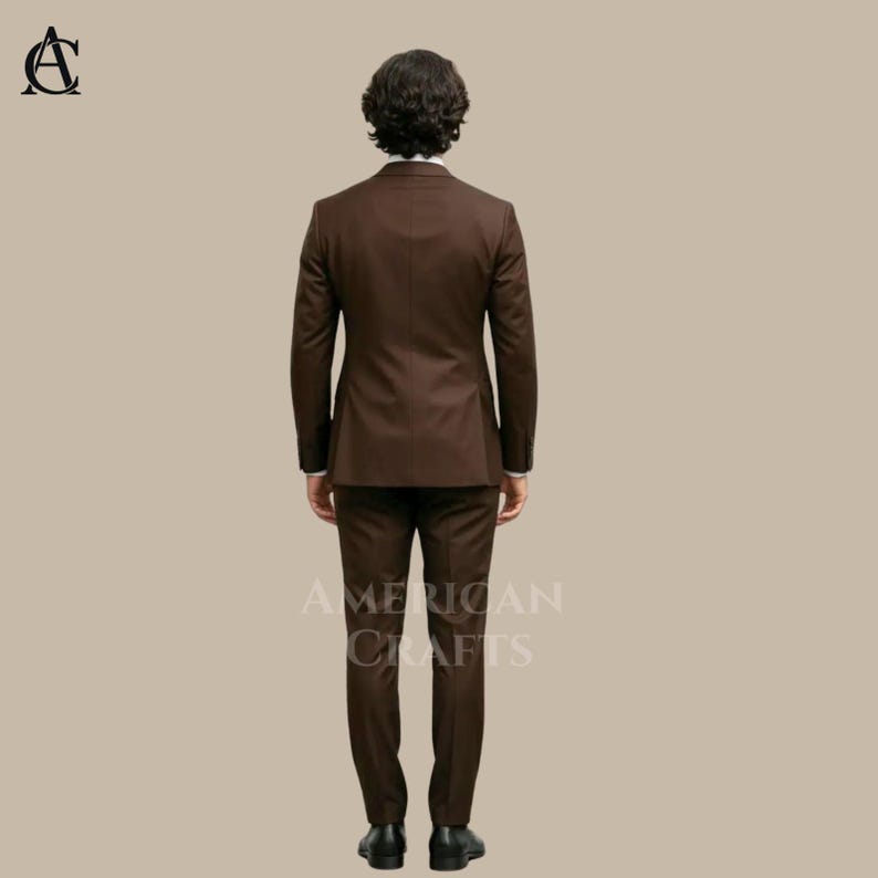 Puede incluir: Un traje marr&oacute;n, que consta de una chaqueta de dos botones y un pantal&oacute;n a juego. El traje es de color liso y parece estar hecho de una tela suave. Las palabras "AMERICAN CRAFTS" est&aacute;n impresas en el pantal&oacute;n. El traje lo lleva una persona.