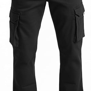 Peut inclure: Pantalon cargo noir avec plusieurs poches sur les jambes. Le pantalon a une coupe droite et est fait d'un tissu durable. Le mod&egrave;le porte des chaussures en cuir marron.