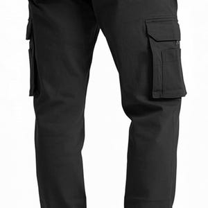 Peut inclure: Pantalon cargo noir avec plusieurs poches sur les c&ocirc;t&eacute;s et &agrave; l'arri&egrave;re. Le pantalon a une fermeture boutonn&eacute;e et une coupe droite classique. Le mod&egrave;le porte des chaussures marron.