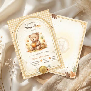 May include: Baby shower invitation featuring a teddy bear illustration holding a pumpkin. The design has a honey theme with the text "A Sweet Little Honey Bear is on the Way". The invitation is in soft, warm tones.