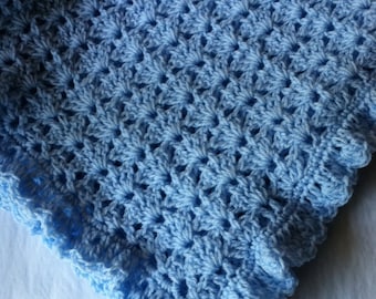May include: A light blue crocheted baby blanket with a scalloped edge.