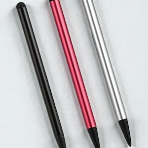 Puede incluir: Tres elegantes lápices ópticos en negro, rojo y plateado, cada uno con punta negra. Los lápices ópticos están dispuestos diagonalmente sobre un fondo blanco, mostrando su acabado metálico liso. Diseñados para dispositivos de pantalla táctil.