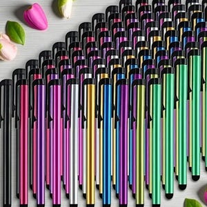Peut inclure: Une collection de stylets colorés dans diverses teintes, notamment noir, rose, violet, argent, or, bleu et vert. Chaque stylet est doté d'une pointe et d'un clip noirs. Les stylos sont disposés de près, créant un affichage vibrant.