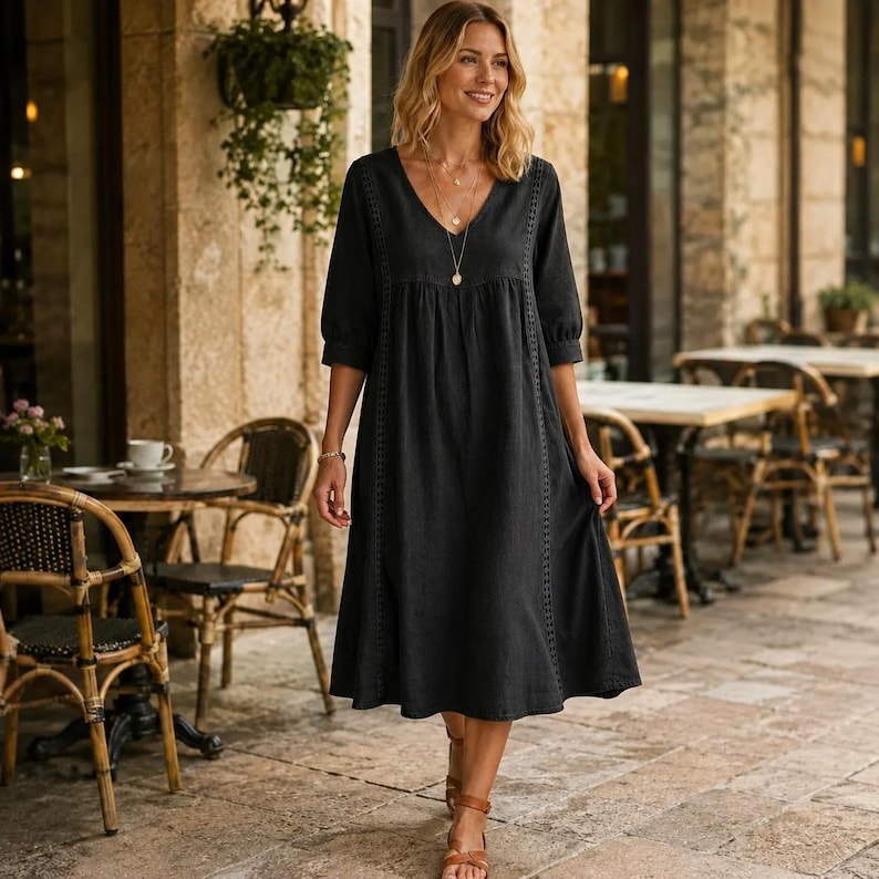 May include: A black midi-length dress featuring a V-neckline, three-quarter length sleeves, and vertical lace trim detailing along the bodice. The garment has a loose, flowing silhouette with a gathered waistline and a simple, solid-colored design.
