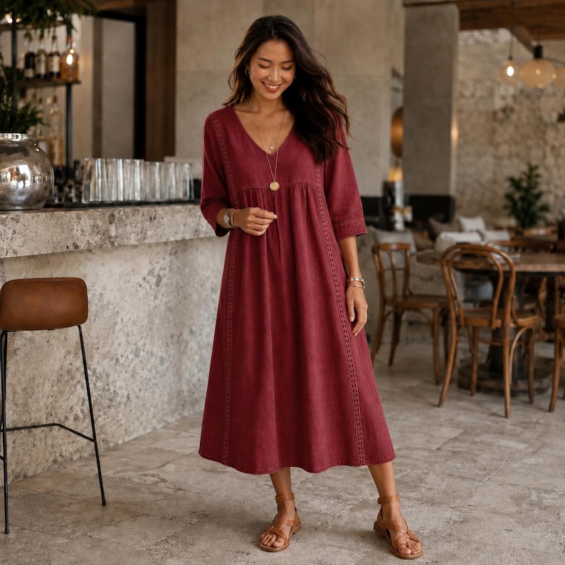 May include: A deep red midi-length dress featuring a V-neckline, three-quarter length sleeves, and vertical lace trim detailing along the bodice and skirt. The garment has a loose, flowing silhouette and is paired with brown strappy sandals.