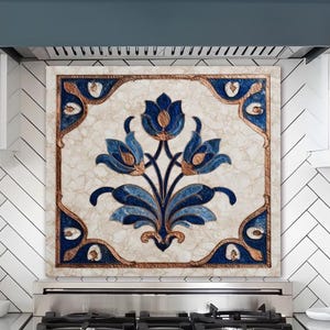 May include: A decorative kitchen backsplash featuring a floral design in shades of blue and gold. The backsplash is installed above a stainless steel gas range. The kitchen has white cabinets and a dark blue range hood.