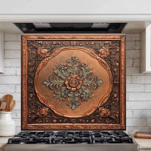 May include: A copper-colored, ornate kitchen backsplash with a floral and leaf design. The square panel is framed and features a central medallion with detailed relief work. The backsplash is installed above a black stove.