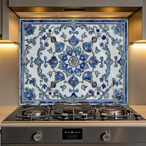 May include: A decorative kitchen backsplash featuring a floral design in shades of blue, teal, and white. The backsplash is installed above a gas stovetop and oven, adding a touch of elegance to the kitchen decor.