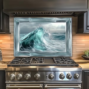May include: A framed glass backsplash featuring a digitally rendered ocean wave in shades of teal and white. The wave is breaking, with water droplets suspended in the air. The backsplash is installed above a stainless steel gas range.