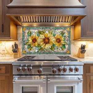 May include: A stained glass kitchen backsplash featuring three large sunflowers with yellow petals and brown centers. The sunflowers are surrounded by green leaves and decorative swirls, set against a marble background.
