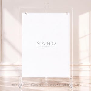 Peut inclure: Un porte-affiche en acrylique transparent composé d'un cadre rectangulaire vertical avec des fixations argentées aux coins supérieurs. Un insert blanc est placé au centre, portant le texte gris NANO ARCHIVE. Le support est transparent.