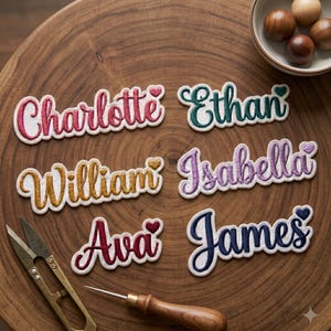 May include: Embroidered name patches in various colors, including red, green, yellow, purple, and blue. Each patch features a different name: Charlotte, Ethan, William, Isabella, Ava, and James. The patches are on a wooden surface.