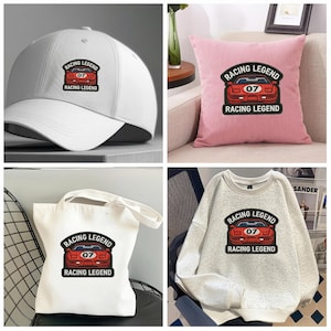 Pode incluir: Um bon&eacute; de beisebol branco, uma almofada rosa, uma sacola branca e um moletom cinza claro. Cada item apresenta um gr&aacute;fico de carro esportivo vermelho com o texto "RACING LEGEND" e o n&uacute;mero "07".