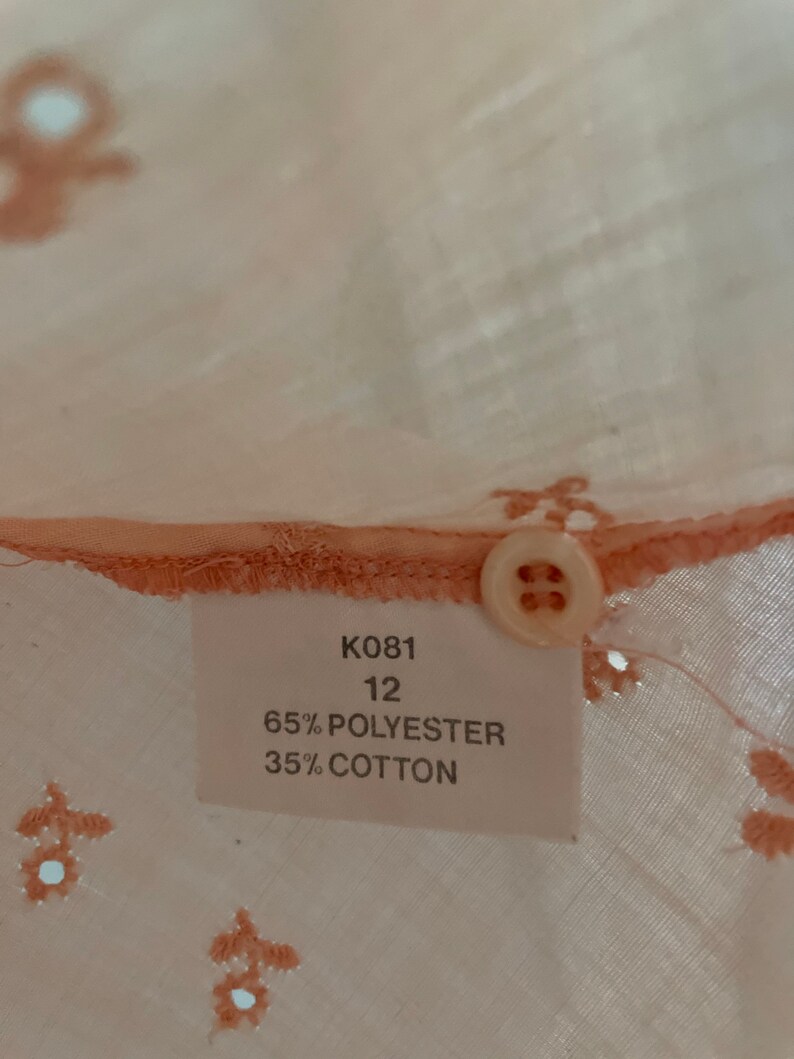 May include: A white tag with black text that reads "K081 12 65% POLYESTER 35% COTTON".