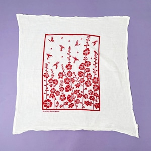 May include: White tea towel with a red floral design featuring hummingbirds. The design is framed in a red border and includes the text "You & Me, Always & Forever".