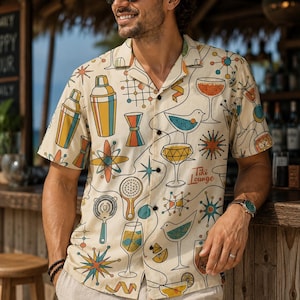 May include: A short-sleeve button-down shirt in cream featuring a colorful mid-century modern print of cocktail shakers, glassware, and starburst shapes. The fabric includes the text Tiki Lounge in a script font among the various drink icons.