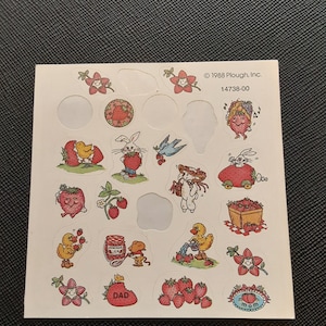 May include: A sheet of vintage stickers featuring various strawberry-themed illustrations. The stickers include images of strawberries, flowers, bunnies, ducks, and the words "DAD" and "MOM". The copyright reads "© 1988 Plough, Inc."