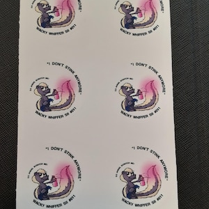 Puede incluir: Hoja de pegatinas redondas con un dibujo de mofeta sosteniendo un pulverizador rosa. Las pegatinas tienen el texto "I DON'T STINK ANYMORE" y "WACKY WHIFFER SII #011". La mofeta es morada, gris y blanca.