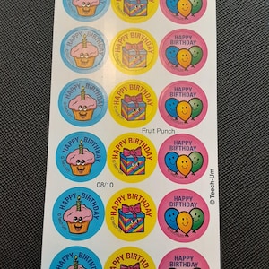 Puede incluir: Hoja de pegatinas de cumpleaños coloridas. Los diseños incluyen cupcakes con velas, regalos envueltos y globos. Cada pegatina tiene las palabras "Happy Birthday". Las pegatinas están en círculos azules, amarillos y rosas.