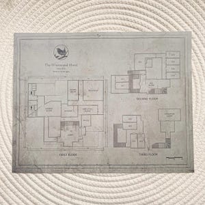 May include: A detailed architectural floor plan of The Wrenwood Hotel, showing three floors with labeled rooms including the dining room, ballroom, and exhibition room. The plan is in shades of grey and includes a bird logo.