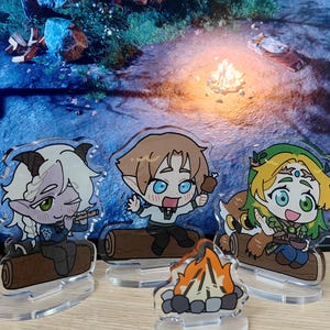 May include: Acrylic figurines of fantasy characters, including a satyr playing a flute, an elf holding a drumstick, and a nature-themed character with an owl. A small campfire figurine is in front. The characters are sitting on logs.