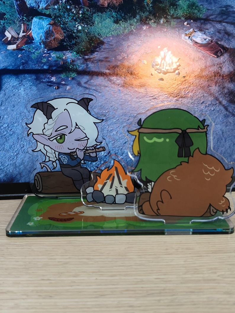 May include: Acrylic figurines depicting a campfire scene with cartoon characters. One figure is a light-skinned character with white hair and horns playing a flute. Another is a green character with a headband, and a brown bear figure.