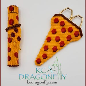 May include: A beaded scissor case shaped like a slice of pizza with red pepperoni and a yellow crust. The case is made with small beads and is a fun and unique way to store scissors.