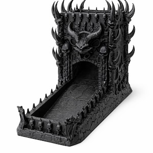 May include: Black dice tower with a gothic castle design. The tower features a horned demon face, skulls, and spires. The dice roll down a ramp into a tray. A unique accessory for tabletop gaming.