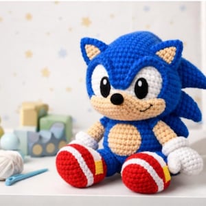 May include: A handmade blue crochet Sonic the Hedgehog plush toy with white gloves and red and white striped shoes. Other toys and yarn are in the background. The plush is sitting on a white surface.