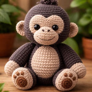 以下が含まれることがあります： グレーとベージュの色合いの手作りの編み物モンキー人形。 ぬいぐるみは、大きな黒い目、笑顔の顔、小さな耳が付いた丸い頭が特徴です。 モンキーはベージュのお腹と茶色の足跡が付いた足を持っています。