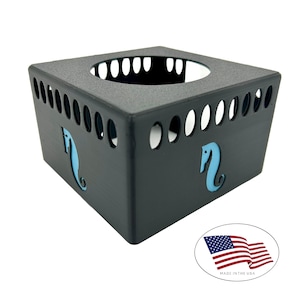 May include: Black metal tissue box holder with a square shape and a seahorse cutout design in light blue. The box has a series of oval cutouts along the sides and a large opening at the top. The product is made in the USA.