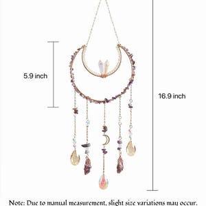 May include: A hanging wall ornament featuring a crescent moon frame adorned with purple stone chips, two clear crystals, and dangling chains with beads and teardrop-shaped pendants. The total height is 16.9 inches and the width is 5.9 inches.