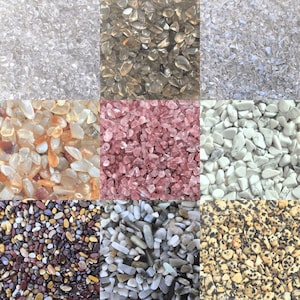 May include: A grid of nine different types of small, polished stones. The stones vary in color, including clear, brown, pink, white, and speckled. The stones are likely used for decorative purposes or in crafts.