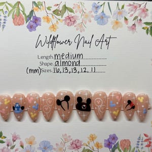 May include: Almond-shaped, medium-length press-on nails with a light pink base. Each nail features a unique design, including Mickey Mouse, hearts, and stars. The set is labeled "Wildflower Nail Art" with size details in millimeters.