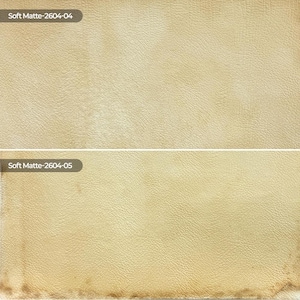 May include: Two rectangular swatches of beige textured material with a matte finish. The top swatch is labeled Soft Matte-2604-04, and the bottom swatch is labeled Soft Matte-2604-05, featuring a slightly darker, weathered edge at the bottom.