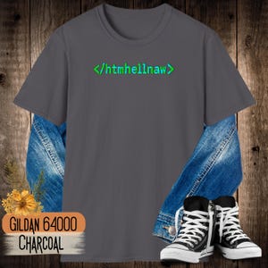 Op de afbeelding: Een antracietgrijs T-shirt met korte mouwen en de groene tekst </htmhellnaw> op de borst. Het T-shirt is gelaagd over een blauw spijkerjack en gecombineerd met zwart-witte hoge sneakers, met een klein geel bloemaccent.