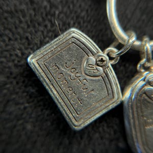 May include: A white ceramic mug with a black handle and the text "But First, Coffee" in a bold, black font. The mug is set against a blurred background, suggesting a cozy setting.