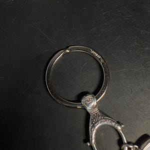 May include: A white ceramic mug with a black handle and the text "But First, Coffee" in a black, bold font. The mug is on a white surface.