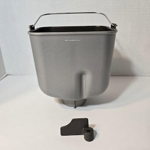 May include: A white ceramic mug with a black handle and the text "But First, Coffee" in a black, bold font. The mug is sitting on a white surface. The mug is approximately 4 inches tall.