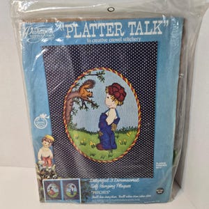 May include: A vintage "Platter Talk" needlecraft kit. The kit features a crewel embroidery design of a child and squirrel. The packaging includes the text "Delightful 3 Dimensional Self Hanging Plaques" and "PATCHES". The background is blue with white polka dots.