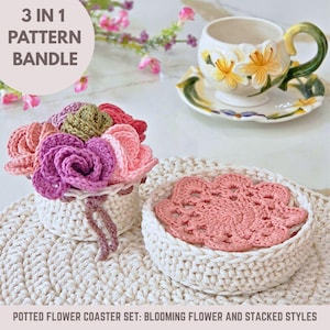 May include: A crochet coaster set featuring a blooming flower and stacked styles. The set includes a white crochet basket with a pink flower coaster inside, and a second basket with a bouquet of crochet flowers in shades of pink, purple, and green.