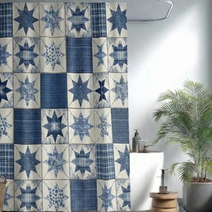 May include: A blue and cream patchwork shower curtain with a star pattern. The curtain features a variety of blue star designs and plaid patterns on a cream background. The shower curtain is hanging in a bathroom with a white tub and a potted plant.