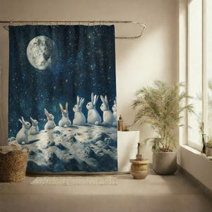 Puede incluir: Cortina de ducha con conejos blancos sobre un paisaje lunar bajo un cielo estrellado. Se ve una luna grande y detallada. La cortina está diseñada para añadir un toque único a la decoración de cualquier baño.