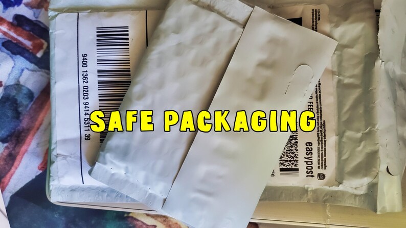 May include: Image of packaging materials, including white padded envelopes and shipping labels. The text "SAFE PACKAGING" is displayed in yellow letters. Barcodes and shipping details are visible.