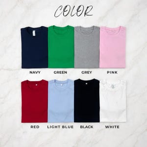 May include: A collection of eight folded t-shirts in various colors: navy, green, grey, pink, red, light blue, black, and white. The word "COLOR" is written in cursive at the top of the image, with each shirt labeled with its respective color name.